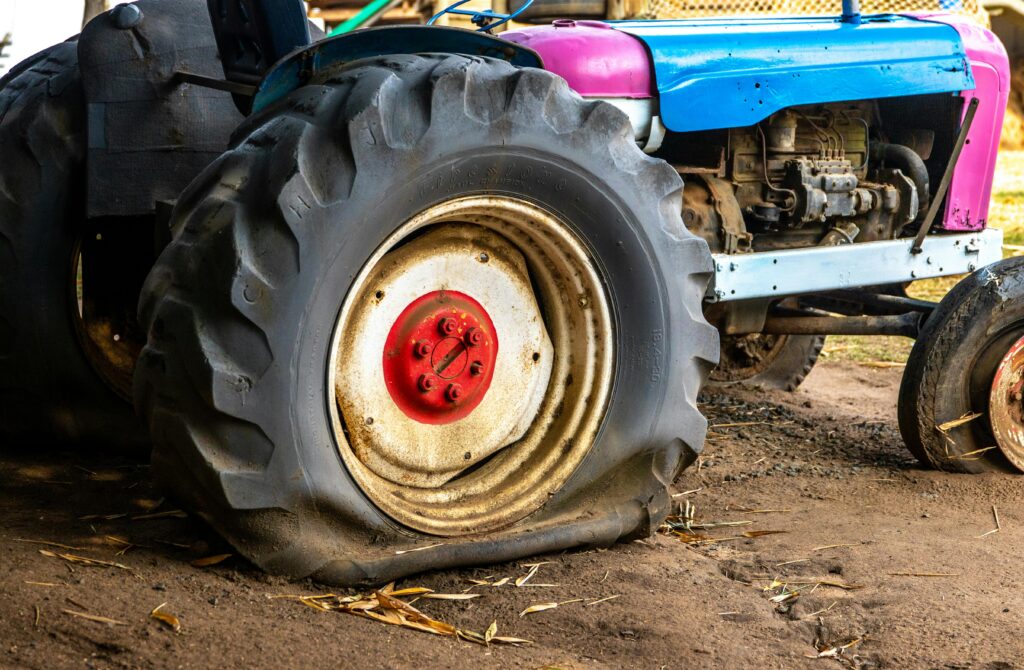 Flat tractor tire causing equipment downtime in the field.
