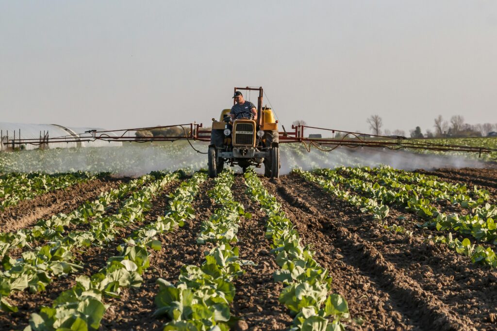 Agricultural field sprayer applying crop protection chemicals with improved spray coverage using a non-ionic surfactant